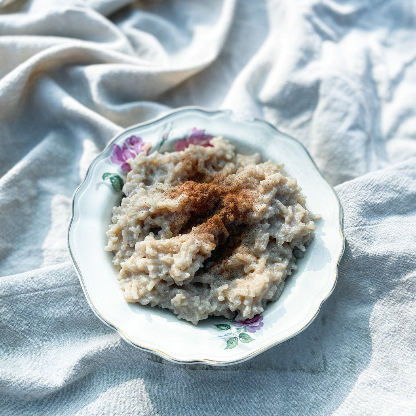 Rice pudding in a decorative bowl on a light fabric background